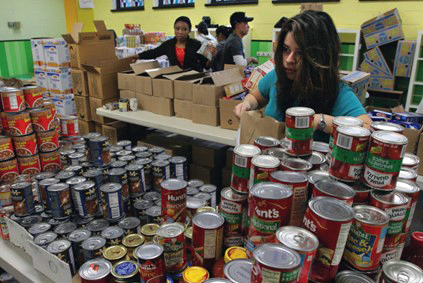 Woman selecting canned items at a grocery store.