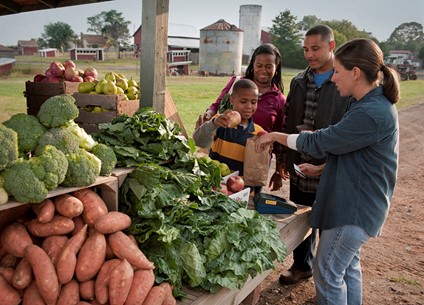 Family at outdoor market buying fresh produce